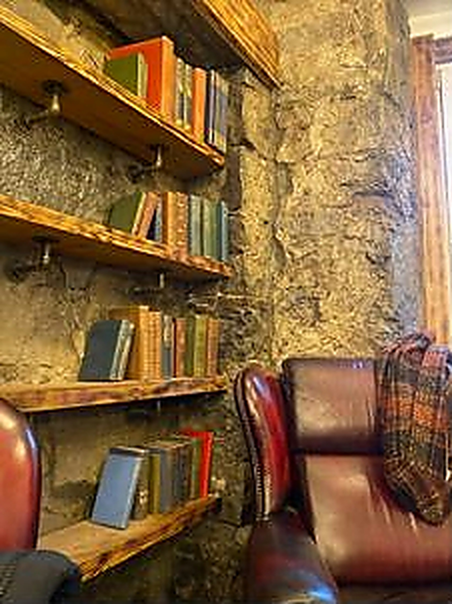 Old books, a leather armchair and the café's stone wall