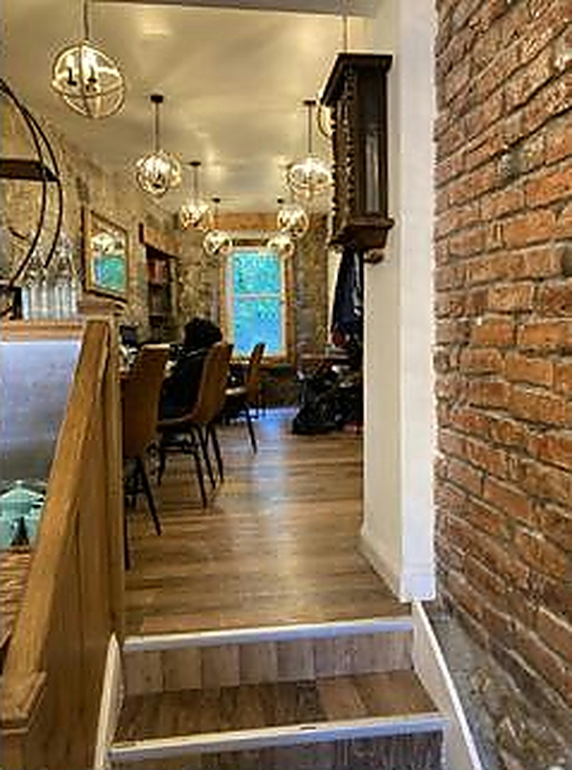 Warm hanging lights, stone walls and cosy seating inside Books N' Cup Cafe
