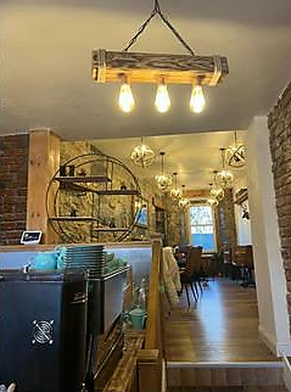 Warm pendant lights and the long stone-walled café interior