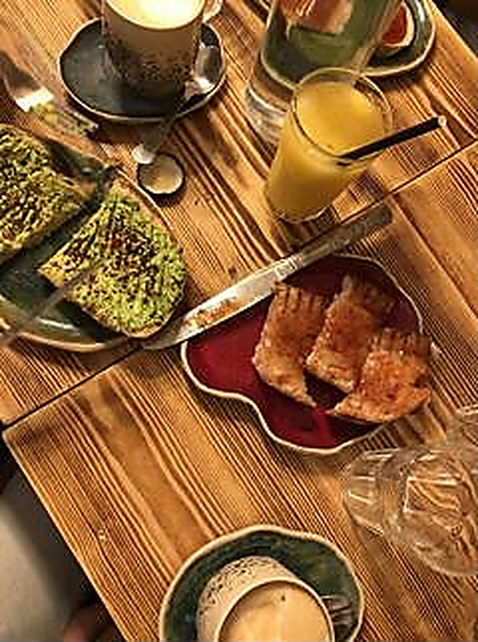 Avocado toast, a croissant and coffee on the café's wooden table