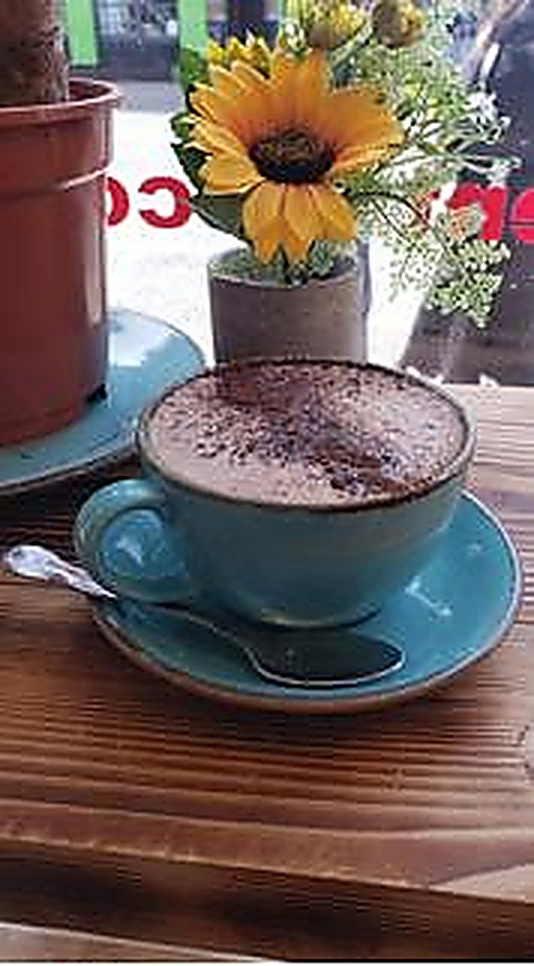 A distinctive blue cup and saucer beside a sunflower