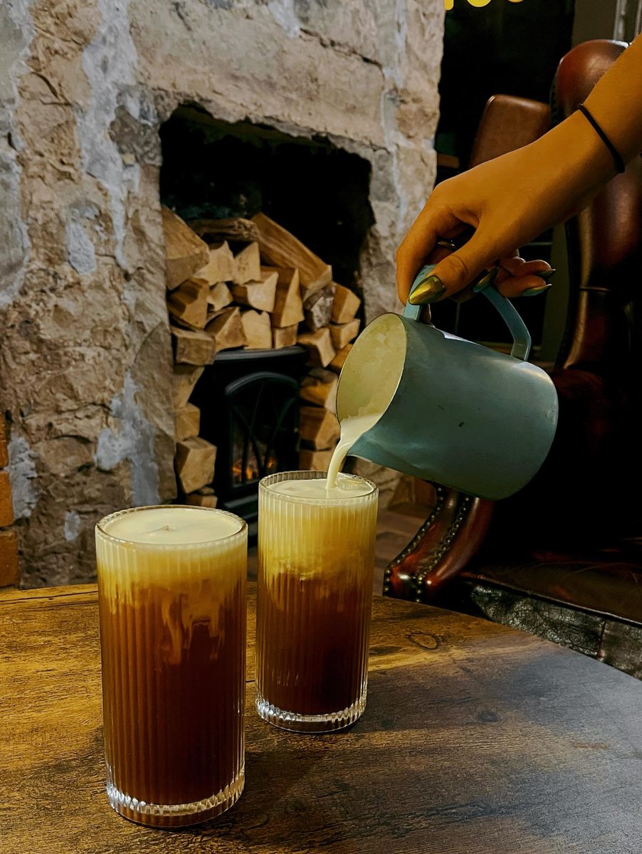 An iced coffee on the table by the fire