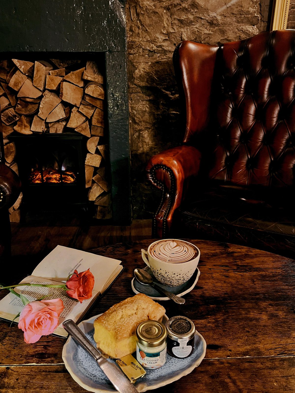 The fireside seat — a scone with jam and clotted cream, and a hot chocolate by the stove